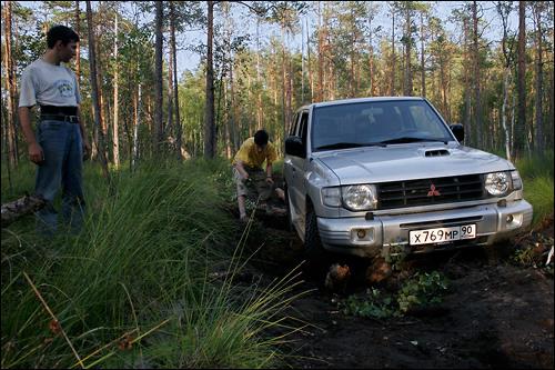 Cabin boy  under brave command of navigator  tryin' to do something about log behind rear wheels...